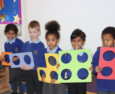 Churchend pupils holding maths shapes