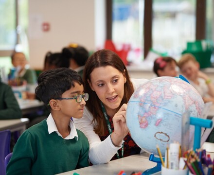 Hawkedon pupil and teacher looking at globe